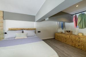 a bedroom with a large bed and some clothes at Loft 2 in Kos