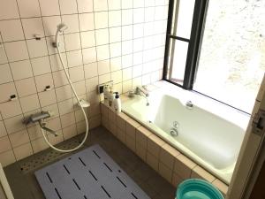 een badkamer met een bad, een wastafel en een raam bij Yamabitoan - Vacation STAY 04295v in Chikushino