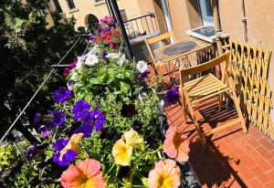 a porch with flowers and a chair on a patio at Casa GEOROSS in Verona