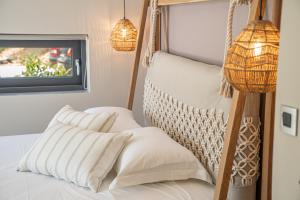 a bed with white pillows and a hanging chair at Villa Fortuna in Ayia Evfimia +24 photos
