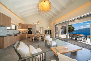 an open kitchen and living room with a table and chairs at Villa Fortuna in Ayia Evfimia