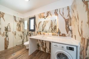 a bathroom with a sink and a washing machine at Villa Fortuna in Ayia Evfimia