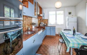 een keuken met blauwe kasten en een tafel. bij Gîte la côte des bleuets de Retourtour in Lamastre