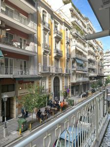 uma rua da cidade com edifícios e pessoas sentadas a mesas em Apartment in the center of Agia Sophia em Tessalônica