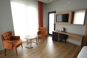 a room with two chairs and a table and a television at POAL GROUP HOTELS in Bostancı