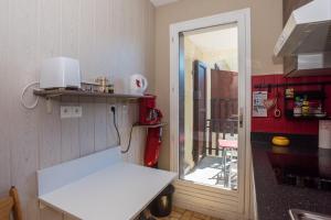 una pequeña cocina con encimera blanca y mesa en Studio Chaleureux, Plein Sud en Villard-de-Lans