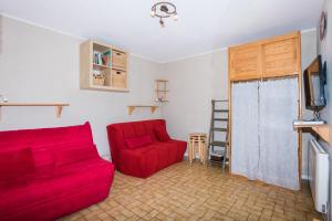 Sala de estar con 2 sofás rojos y TV en Studio Chaleureux, Plein Sud en Villard-de-Lans