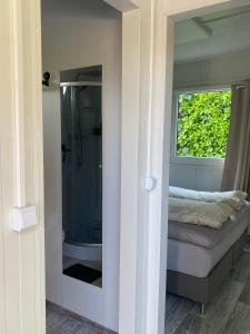 a bathroom with a shower and a couch and a window at Tiny House QiriH in Zierikzee