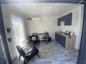 uma sala de estar com um sofá, cadeiras e uma mesa em Tiny House QiriH em Zierikzee