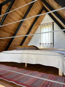 a bed in a attic with a window at Tlos Nature Houses in Yaka