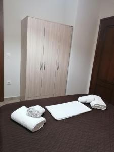 a bedroom with two towels on a bed with a cabinet at Kali Luxury Apartments -Garden-Gold- in Agios Nikolaos