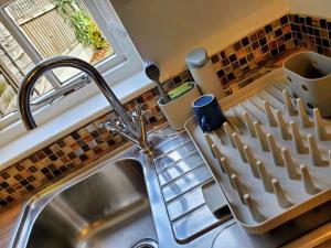 a kitchen sink with a dish drying rack next to a window at Court Cottage, 2 bed period house in Sarre