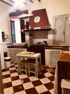eine Küche mit einem Tisch und einer Uhr an der Wand in der Unterkunft Casa Rural con encanto Señorio Manchego ALBACETE in Yeste