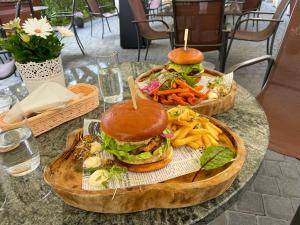 dos platos de madera con sándwiches y papas fritas en una mesa en Park Rekreacyjno-Biznesowy Las Woda, en Wilga