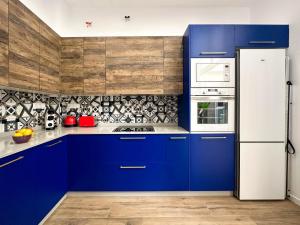 a kitchen with blue cabinets and a white refrigerator at Capitan Rueda Apartments Alicante - Parking 10 euros per day in Alicante