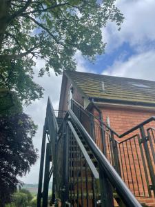 eine Holztreppe, die zu einem Backsteingebäude führt in der Unterkunft Pilgrim Hotel in Hereford