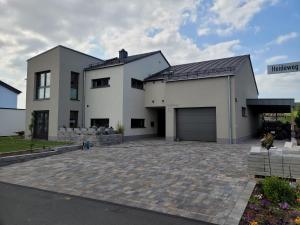 a large white house with a garage at Beim Eifelfranken in Darscheid