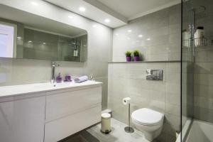 Un baño blanco con inodoro y lavabo. en Eshkol Housing Haifa - Luxury Villa Panoramic Sea View חיפה כרמל, en Haifa 21 fotos más