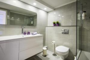 a white bathroom with a toilet and a sink at Eshkol Housing Haifa - Luxury Villa Panoramic Sea View in Haifa