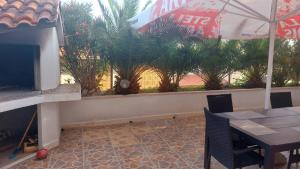 a patio with a table and a television and trees at Apartments Duce (122) in Duće