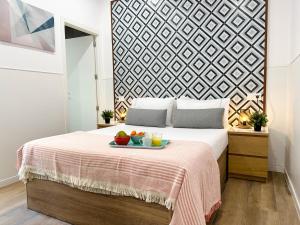 a bedroom with a bed with a tray of fruit on it at Capitan Rueda Apartments Alicante - Parking 10 euros per day in Alicante