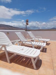 a row of white chairs sitting on a roof at Dunas de Famara in Famara