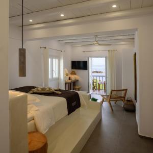 1 dormitorio con 1 cama grande y balcón en Nefeli Sunset Studios en Pollonia