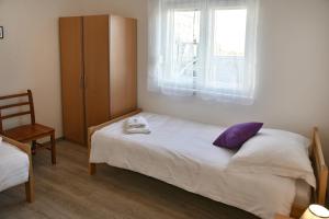 a small bedroom with a bed and a window at Apartman Badi in Dugopolje