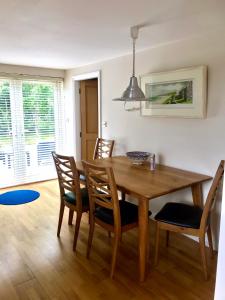 a dining room with a wooden table and chairs at Red Deer Cosy Apartment in Letterfrack Connemara in Letterfrack