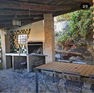 un patio con mesa y horno de ladrillo en Casa Rural El Gandulillo, en Castril