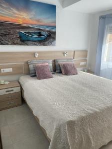 a bedroom with a bed with a painting on the wall at Apartamento Calpe in Calpe