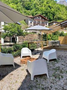 a group of white chairs and tables and an umbrella at Casa Pirri in Espinama