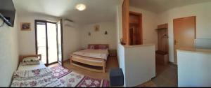 een woonkamer met 2 bedden en een keuken bij S Kilaći in Mostar
