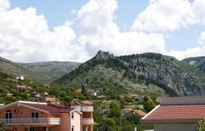 een klein stadje met een berg op de achtergrond bij S Kilaći in Mostar