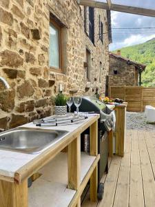a kitchen with a sink and a stone building at Casa Pirri in Espinama