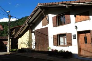 a white house with wooden doors and windows at Casa Pirri in Espinama