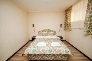 um quarto com uma cama num quarto em TwinHouse Karakol em Karakol