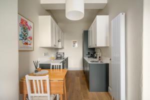 una piccola cucina con tavolo in legno e una sala da pranzo di 2BR New Town Castle View Apartment a Edimburgo