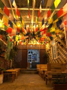 Habitación con bancos de madera y techo con banderas coloridas. en Hello KTM Hostel en Katmandú