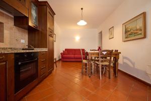 eine Küche und ein Esszimmer mit einem Tisch und einem roten Sofa in der Unterkunft Antichi Palmenti - Alloro in San Vincenzo