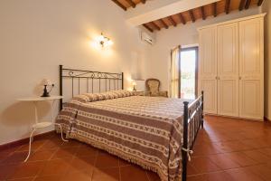 um quarto com uma cama, uma cadeira e uma janela em Antichi Palmenti - Alloro em San Vincenzo