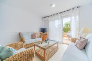 - un salon avec un canapé, des chaises et une table dans l'établissement Menorca Duplex Javea Montanar II by Rock Rentals, à Platja de l'Arenal