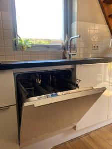 uma máquina de lavar louça numa cozinha com um lavatório em Guesthouse Katwijk aan Zee em Katwijk aan Zee