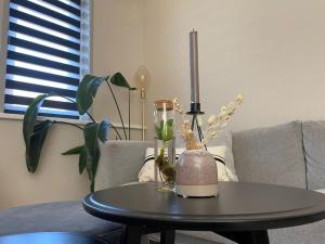 a table with a vase and a lamp on a couch at Guesthouse Katwijk aan Zee in Katwijk aan Zee