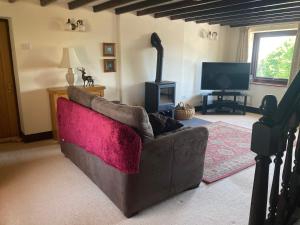 a living room with a couch and a television at The Smithy in Richmond