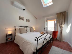 1 dormitorio con 1 cama con sábanas blancas y ventana en La Finestra sul Molo - by MyHomeInComo, en Torno