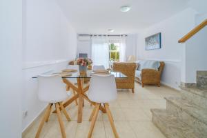 une salle à manger avec une table en verre et des chaises blanches dans l'établissement Menorca Duplex Javea Montanar II by Rock Rentals, à Platja de l'Arenal