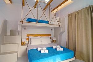 a bedroom with a bed with blue sheets at Coralli Beach Apartments in Mikri Vigla