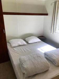 1 dormitorio con 2 almohadas blancas en una cama en Maison de 3 chambres avec piscine partagee terrasse amenagee et wifi a Argences en Aubrac, en Banes