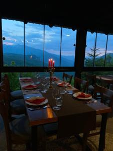 a table with wine glasses and candles on top of it at Hotel Neda Galichnik in Galičnik